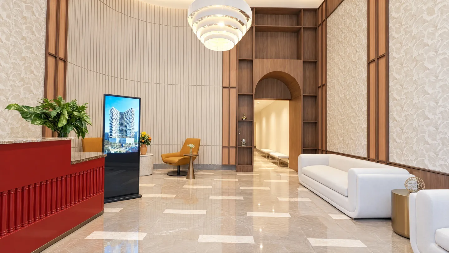 Double-height lobby with reception, pendant lamp and a wooden arch leading to the hallway